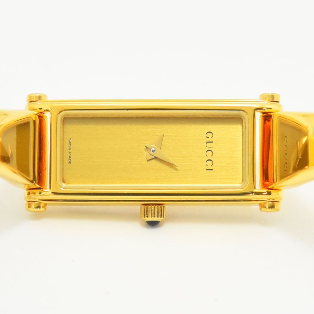 VINTAGE WATCHES FASHIONのGUCCI 1500Lレディースバングルウォッチ。ゴールドカラーの長方形ケースとミニマルな文字盤が特徴の洗練されたスイス製腕時計