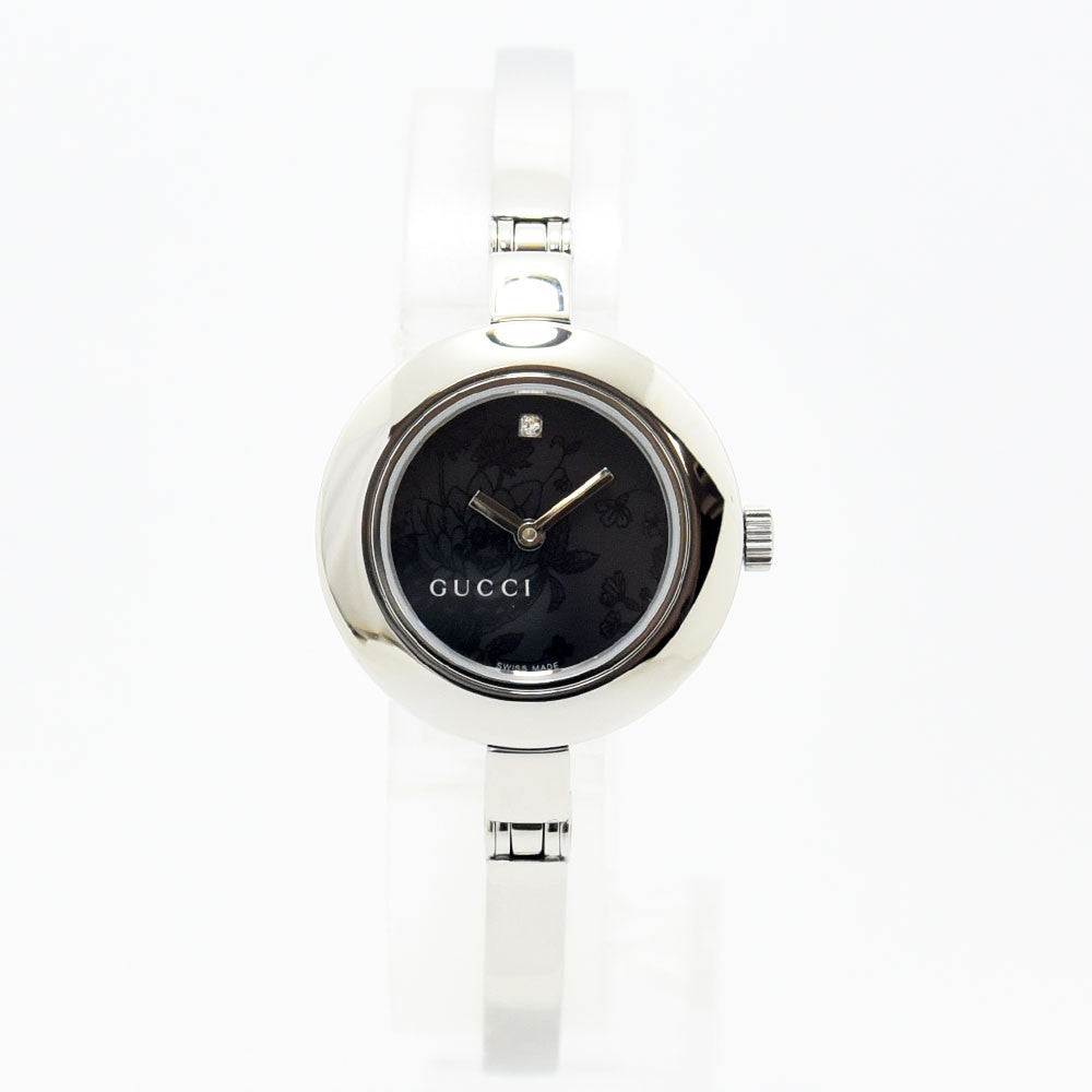 VINTAGE WATCHES FASHIONのGUCCIレディースバングルウォッチ。シルバーのステンレス製で、ブラックの文字盤にフローラル柄と12時のダイヤモンドが輝くエレガントな腕時計。