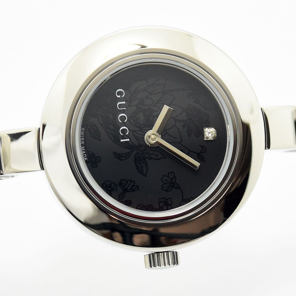 VINTAGE WATCHES FASHIONのグッチ製レディースバングルウォッチ。ブラックのフローラル文字盤に12時位置のダイヤモンドが輝くシルバーのステンレススチール製腕時計。