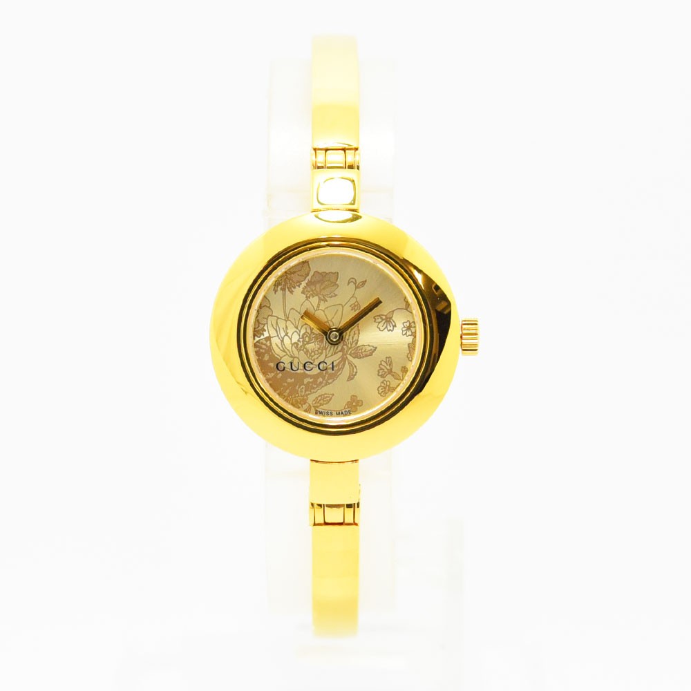VINTAGE WATCHES FASHIONのゴールドトーンのステンレス製GUCCIレディースバングルウォッチ。文字盤にフローラルモチーフが施されたエレガントなデザイン。