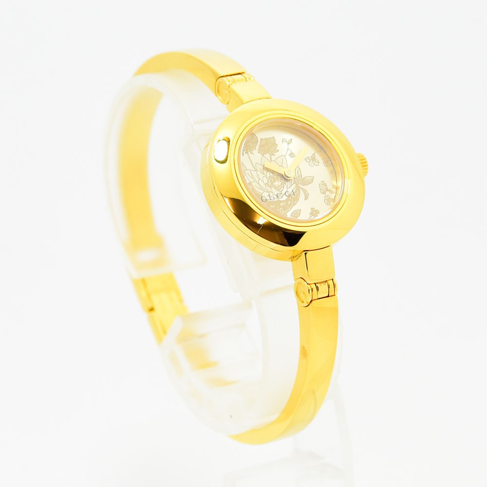 VINTAGE WATCHES FASHIONのゴールドトーンステンレス製GUCCIレディースバングルウォッチ。文字盤にフローラルモチーフが施されたエレガントなデザイン。