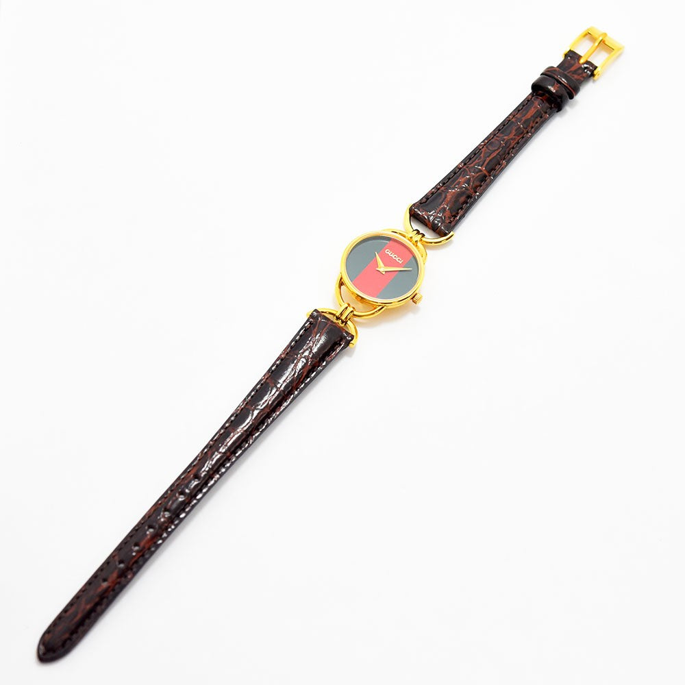 VINTAGE WATCHES FASHIONのグッチ製ヴィンテージレディース腕時計。グリーンとレッドの文字盤にゴールドのラウンドケース、ブラウンの型押しレザーベルトが特徴。