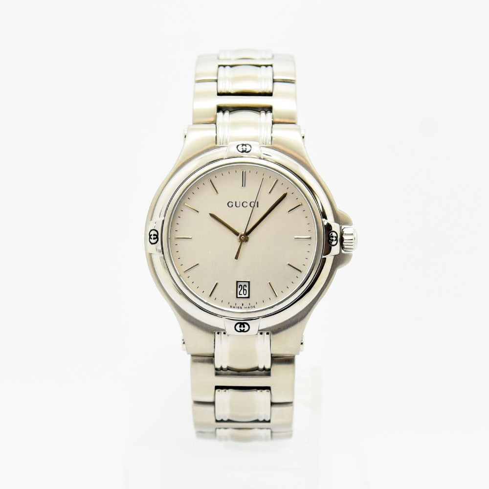 VINTAGE WATCHES FASHIONのシルバーカラーのステンレススチール製Gucciアナログ腕時計。日付表示とロゴ入りベゼルが特徴。