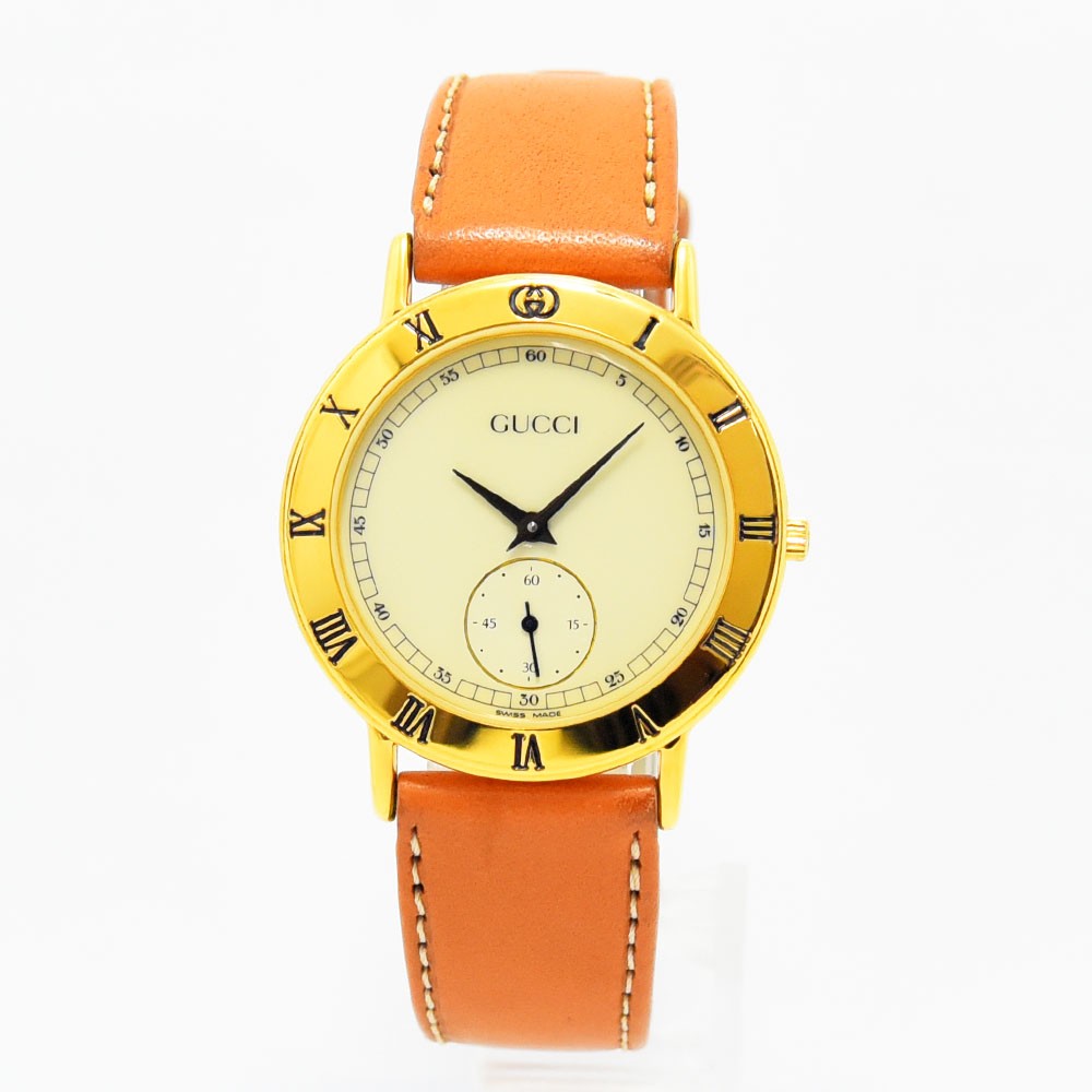 VINTAGE WATCHES FASHIONのGucciヴィンテージ腕時計3000.2M。ゴールドケースにオレンジのレザーベルト、ローマ数字の文字盤が特徴的なスイス製ウォッチ