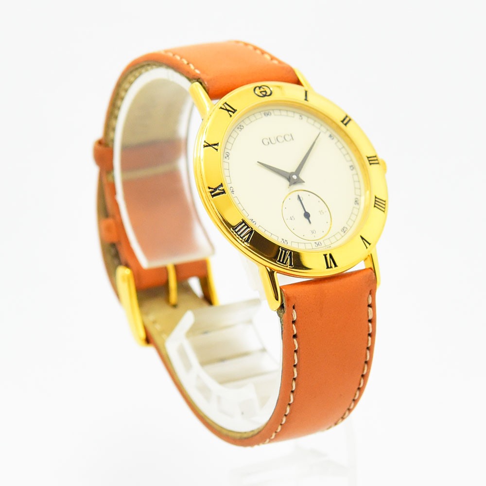 VINTAGE WATCHES FASHIONのGucciヴィンテージ腕時計。ゴールドケースにオレンジのレザーベルト、ローマ数字の文字盤が特徴。