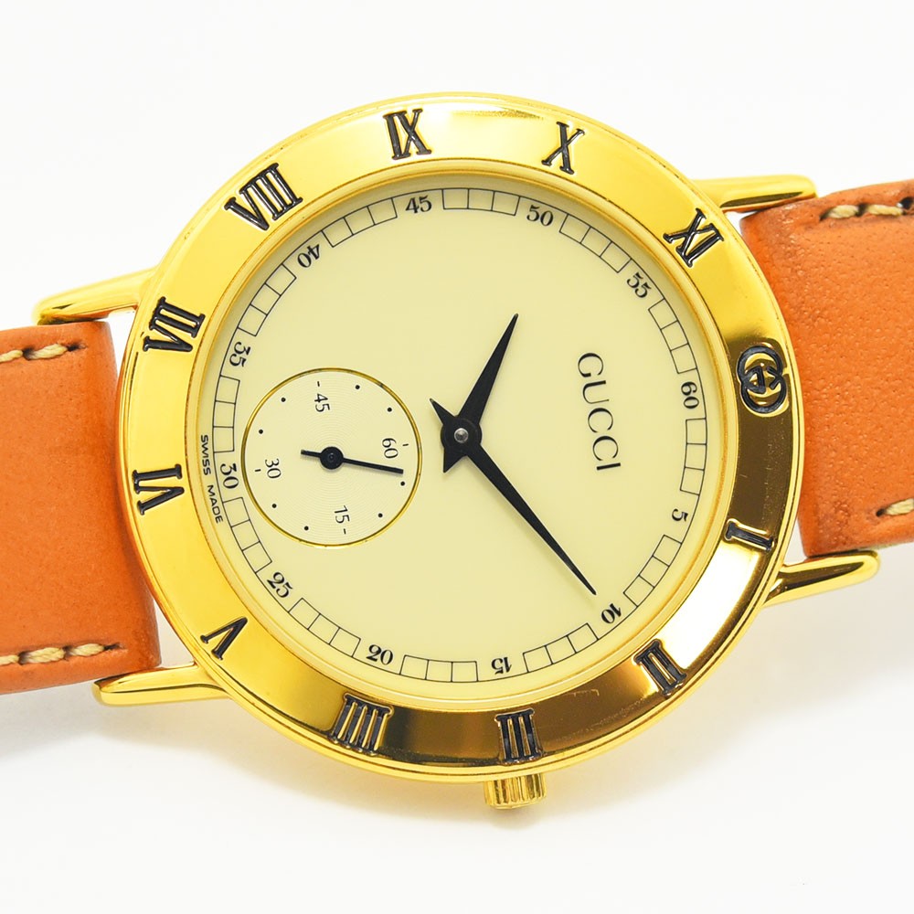 VINTAGE WATCHES FASHIONのグッチ製ヴィンテージ腕時計。ゴールドケースにローマ数字、オレンジのレザーベルトが特徴。