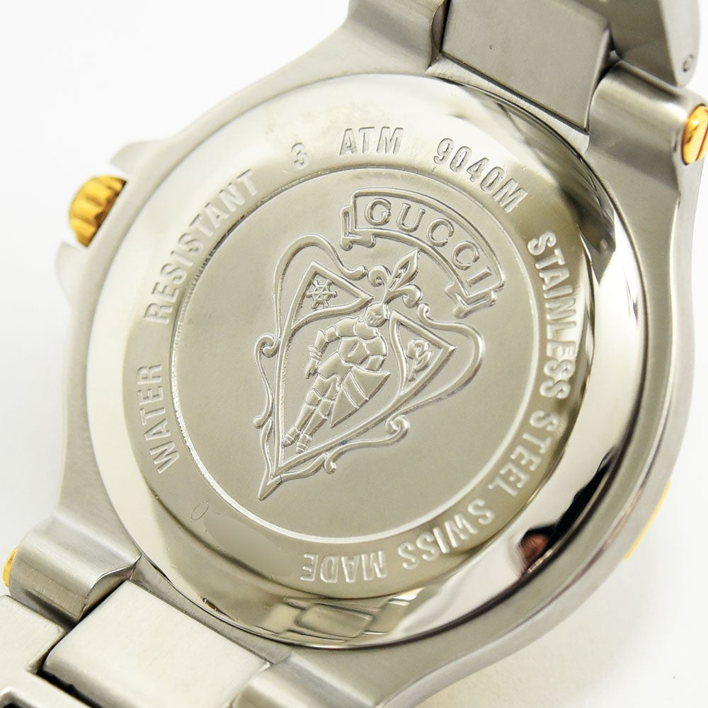 VINTAGE WATCHES FASHIONのGUCCIヴィンテージ腕時計の裏蓋。ステンレススチール製でブランドロゴと紋章が刻印された詳細なクローズアップ。