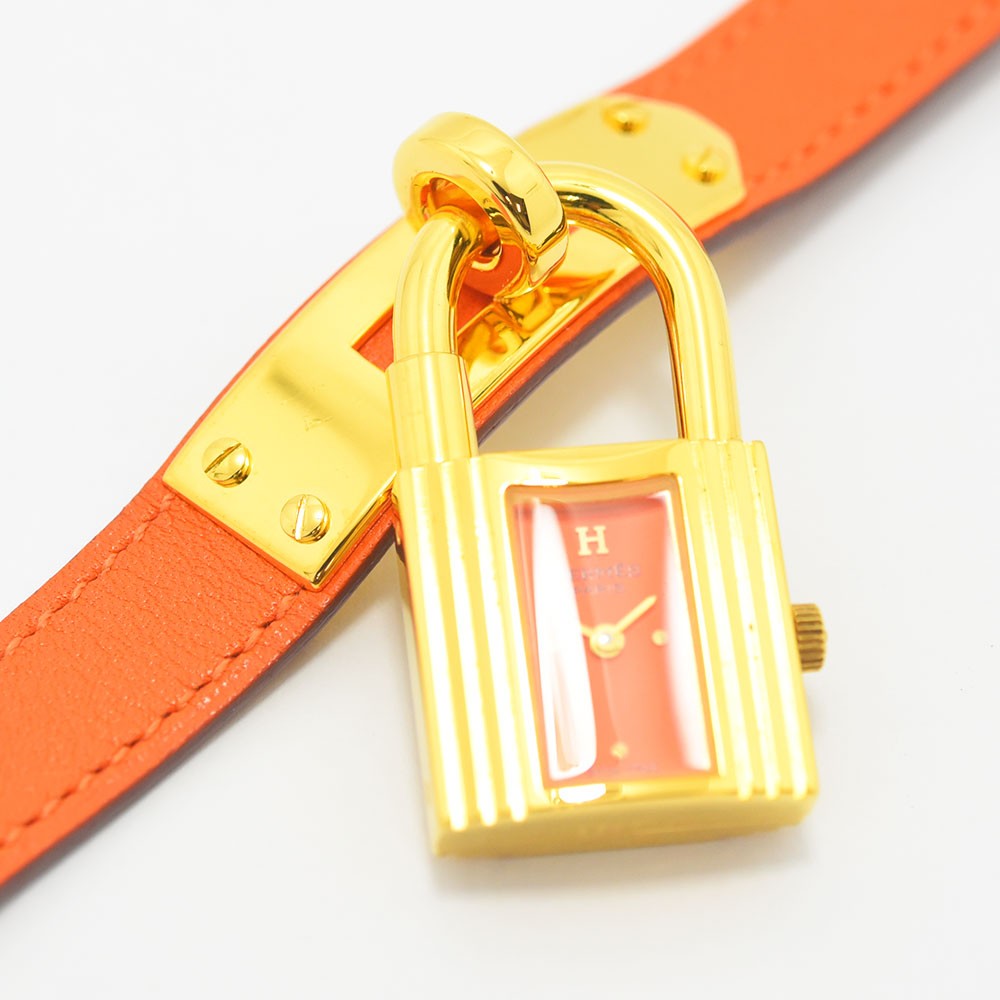 VINTAGE WATCHES FASHIONのエルメス ケリーウォッチ。ゴールドの南京錠型ケースと鮮やかなオレンジのレザーベルトが特徴のレディース腕時計。