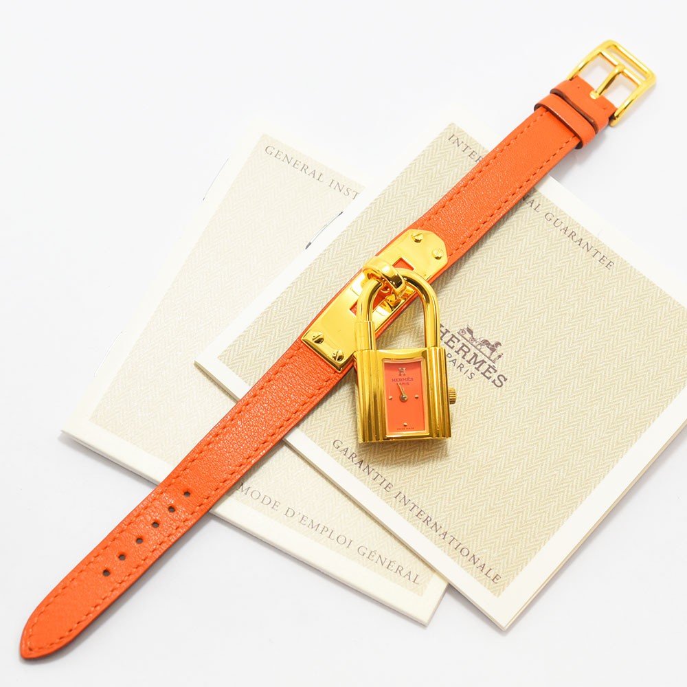 VINTAGE WATCHES FASHIONのエルメス ケリーウォッチ。鮮やかなオレンジのレザーベルトとゴールドの南京錠型ケースが特徴のレディース腕時計。