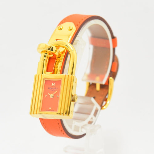 VINTAGE WATCHES FASHIONのエルメス ケリーウォッチ。ゴールドの南京錠ケースと鮮やかなオレンジのレザーベルトが特徴のレディース腕時計
