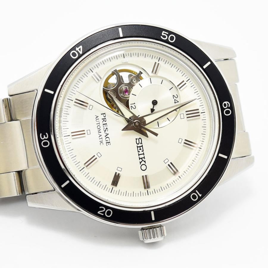 VINTAGE WATCHES FASHION プレザージュ オートマチック ウォッチ。オフホワイトの文字盤、ローマ数字インデックス、オープンハートデザイン、ブラックセラミックベゼル、ステンレススチールブレスレット。